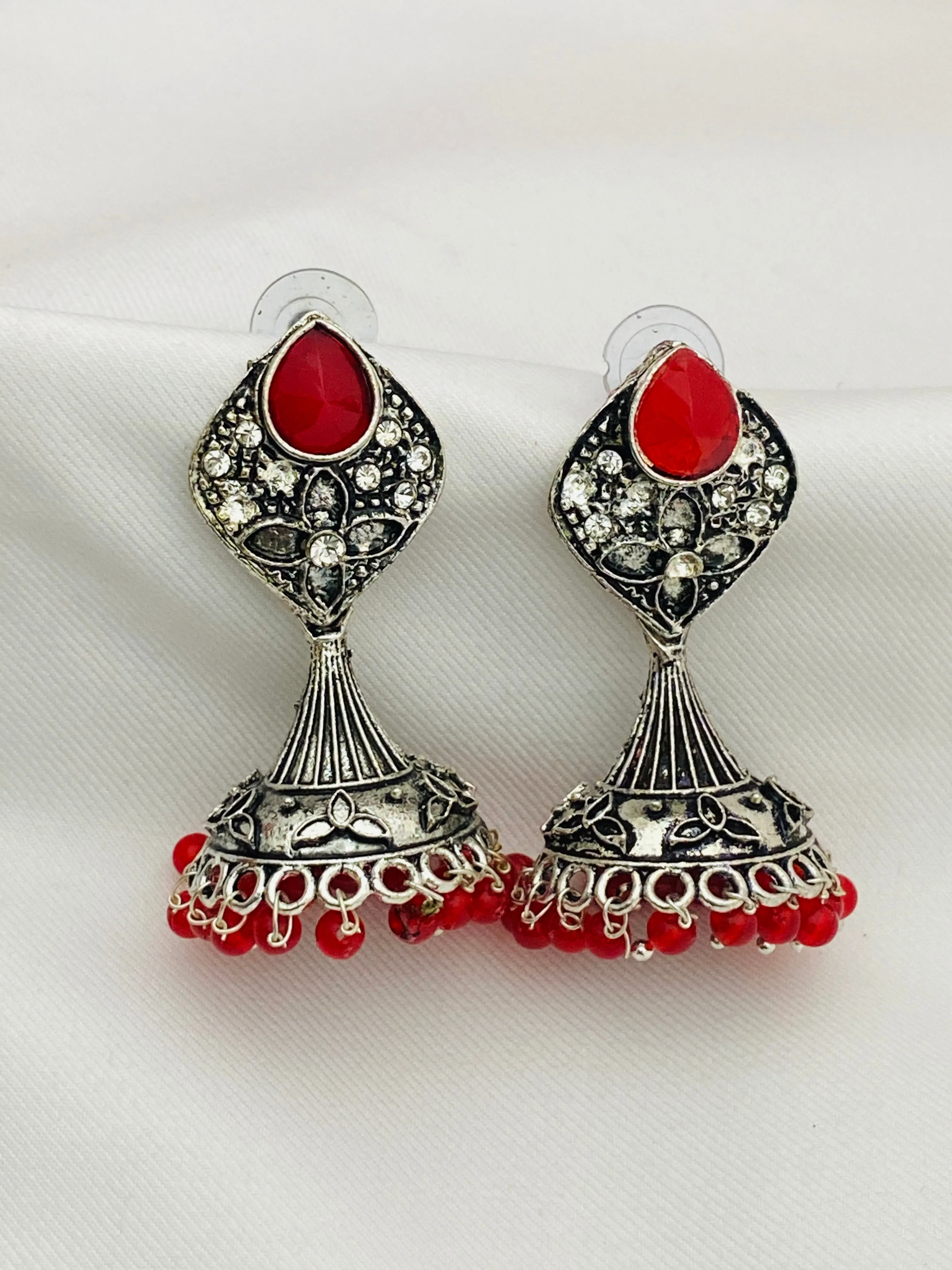 Alluring Red Stone Studded Floral Design German Silver Plated Oxidized Jhumka Earrings For Women