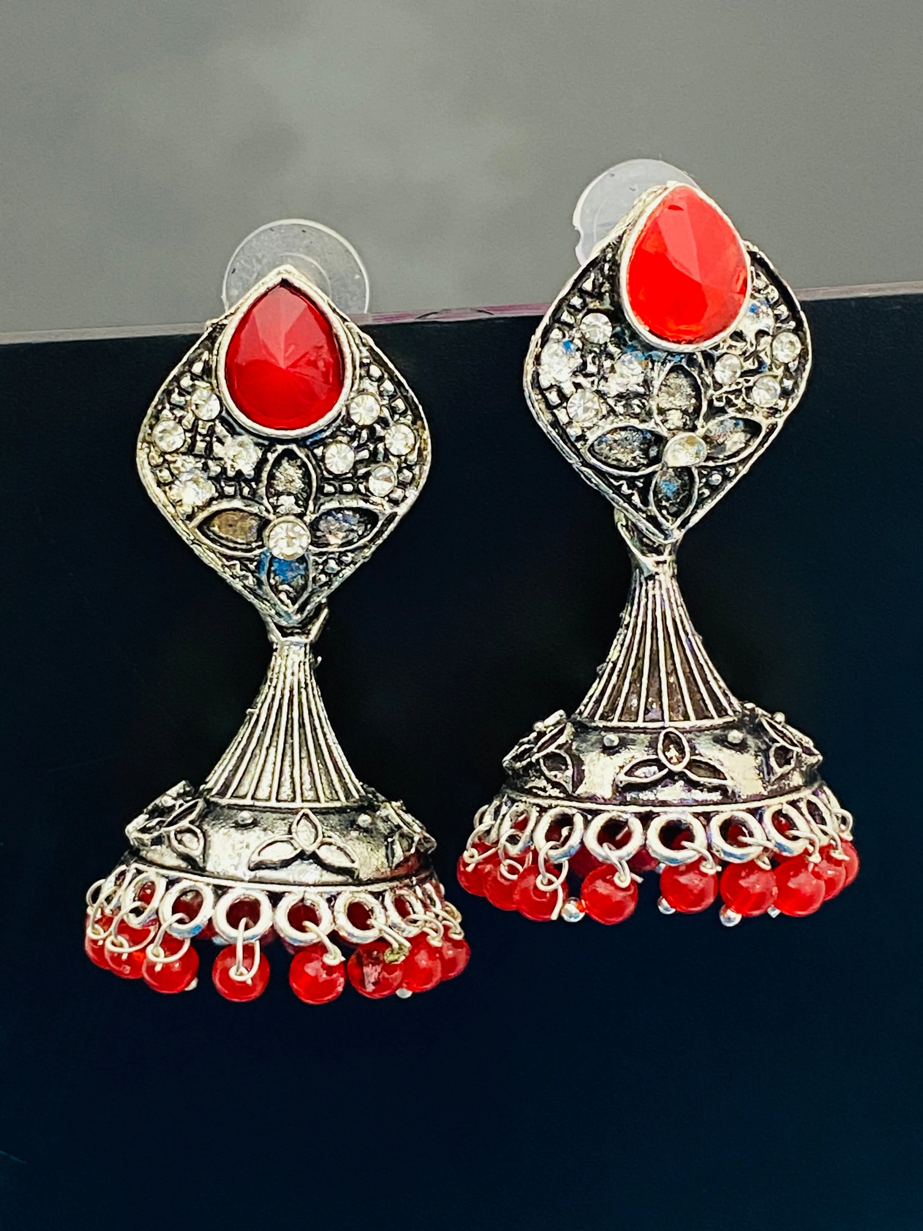 Alluring Red Stone Studded Floral Design German Silver Plated Oxidized Jhumka Earrings For Women